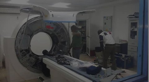 Engineers installing a CT scanner in a hospital room