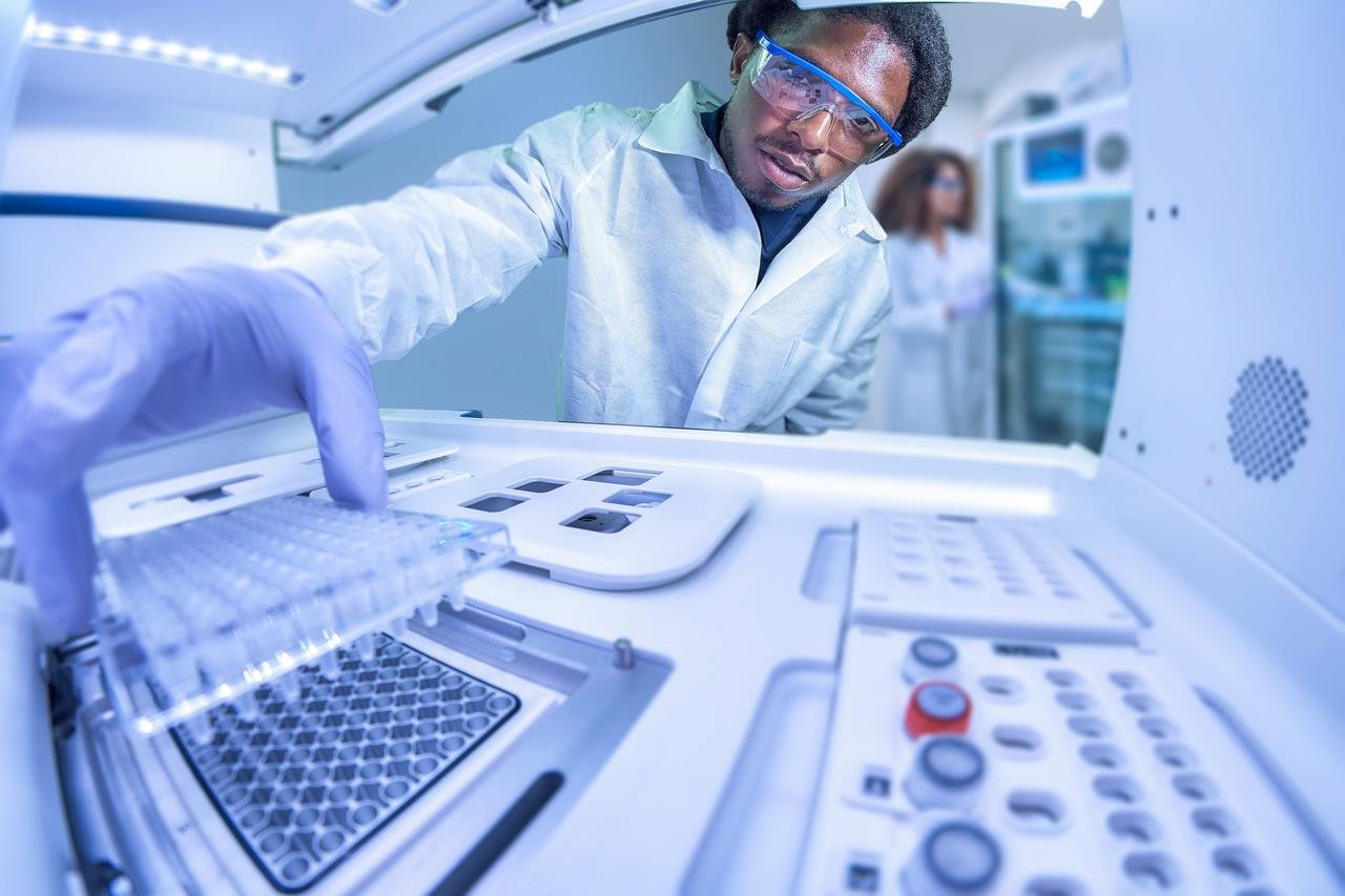 Lab technician loading a sample plate into a diagnostics analyzer